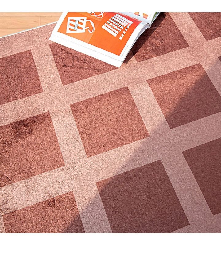 a book laying on top of a brown and white checkered rug with an orange sticker