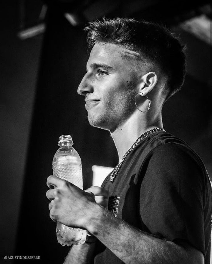 a black and white photo of a man holding a water bottle in his right hand