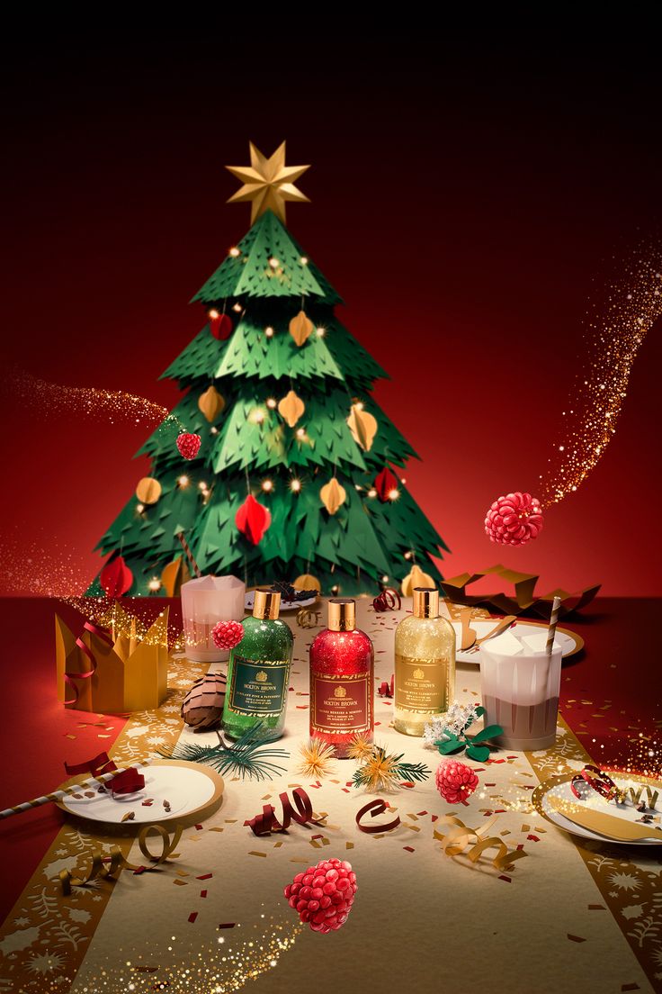 a christmas tree surrounded by bath products on a table with confetti around it