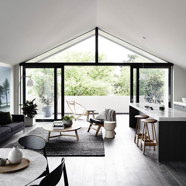 a living room filled with furniture next to a kitchen and an open concept dining area