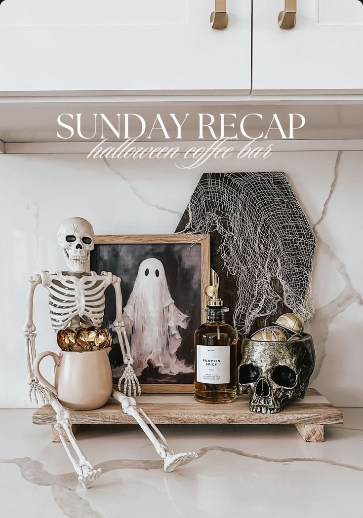 a white kitchen counter top with halloween decorations on it and a skeleton holding a bottle