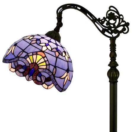 a lamp that is sitting on top of a table next to a light fixture with a purple glass shade