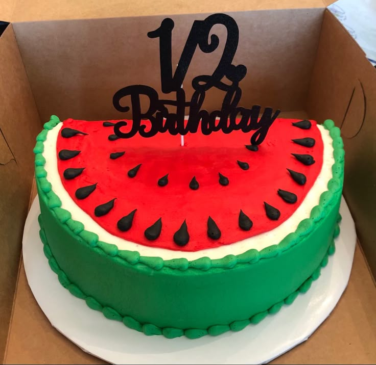 a watermelon birthday cake in a box with the number twenty eight on top