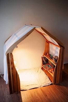 a bed made out of wood with a book shelf in the middle and a light on top