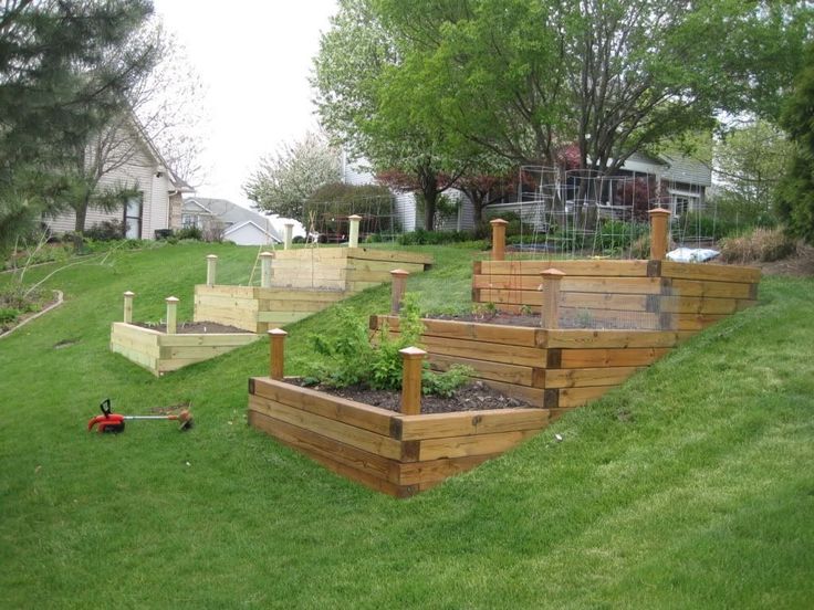 several wooden raised planters in the grass