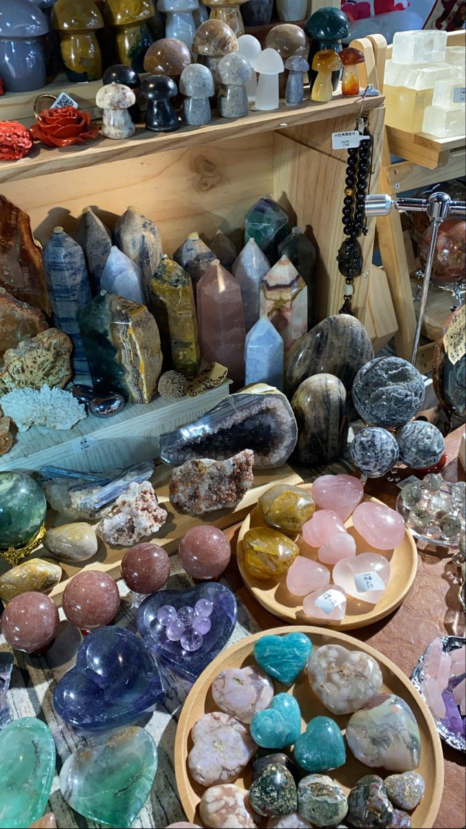 many different types of rocks and stones on display in a store window with wooden bowls full of them