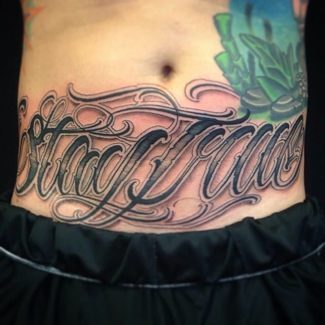 a man's stomach with the word tattoo on it