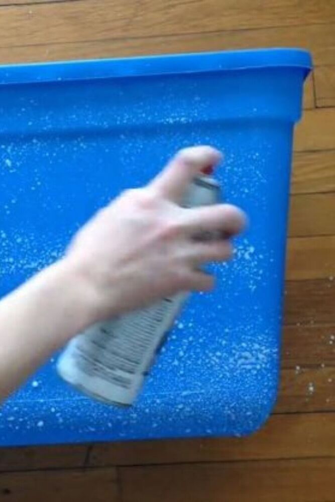 a person's hand is holding a rag in a blue container