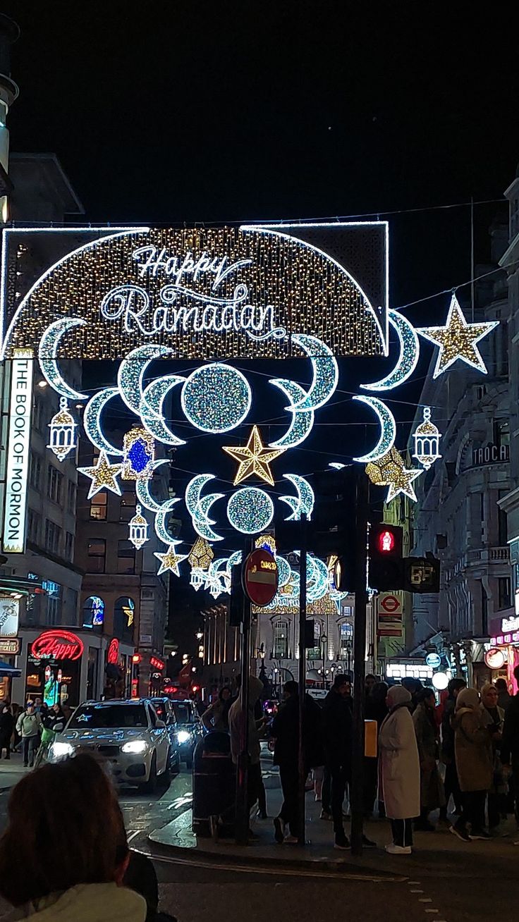 people are walking down the street in front of an arch decorated with stars and crescents