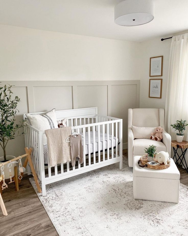 a baby's room with white furniture and decor