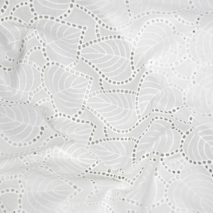 an image of white fabric with circles and leaves on the top, as well as dots