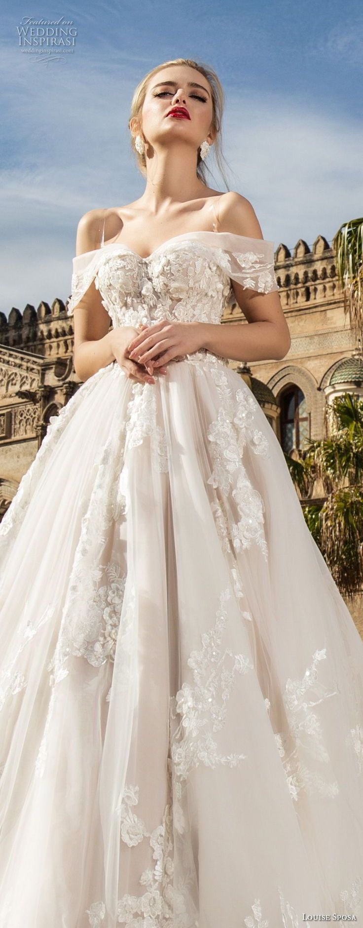 a woman in a wedding dress posing for the camera with her hands on her hips