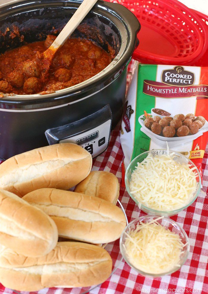 some bread rolls and meatballs are on a table next to a crock pot