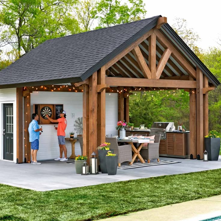 two people standing in front of a covered outdoor kitchen