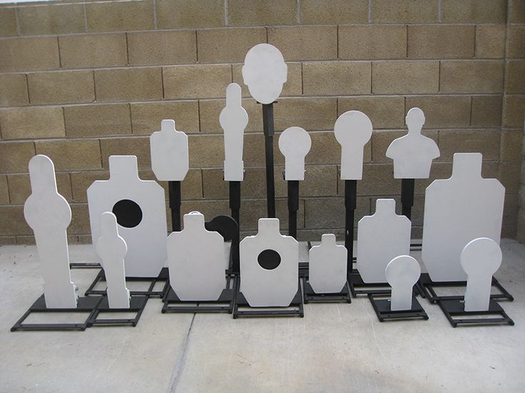 a group of white and black vases sitting on top of each other in front of a brick wall