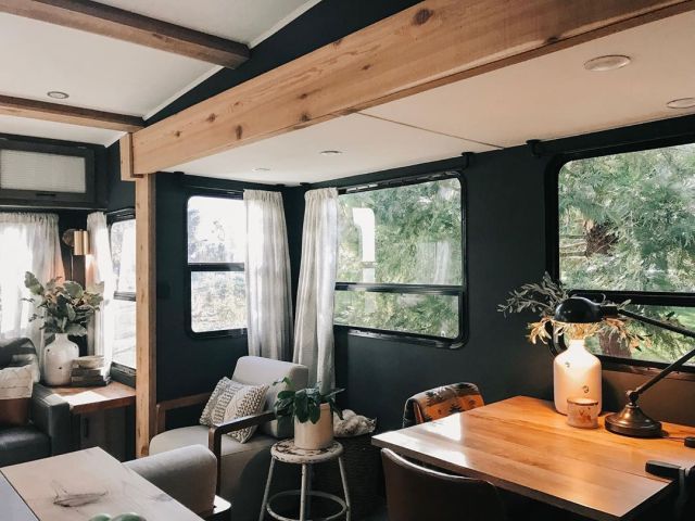 a living area with couches, tables and windows