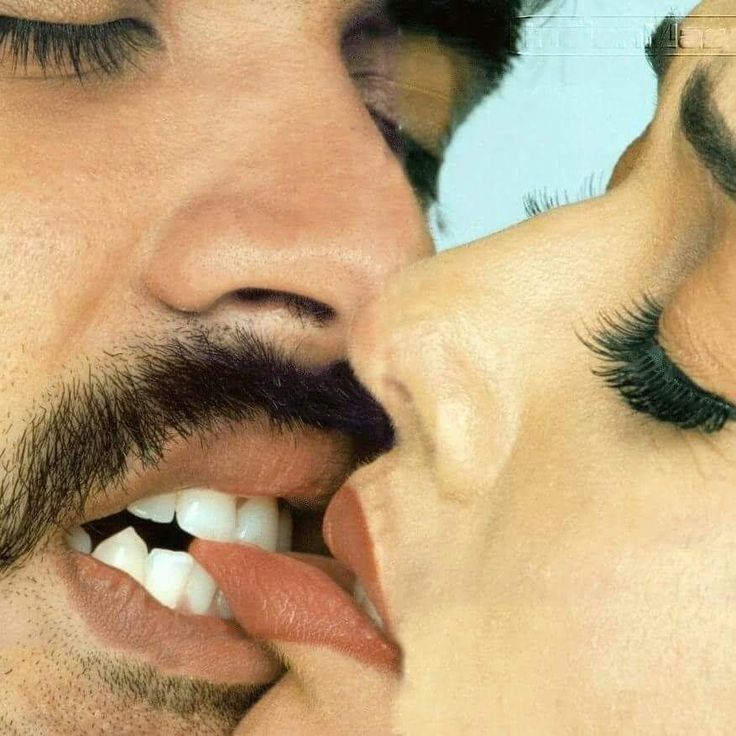 a man and woman kissing each other with their noses close together