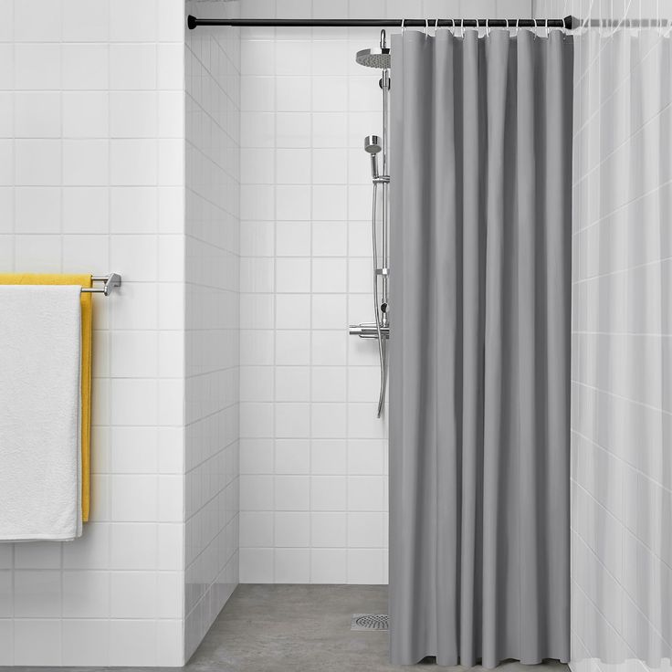 a bathroom with a shower curtain and white tile walls