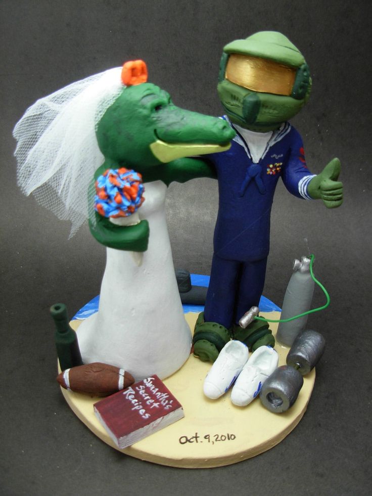 a wedding cake topper with an alligator and bride