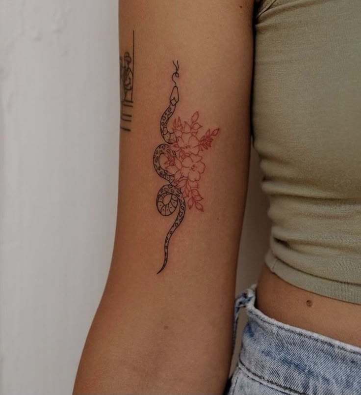 a woman's arm with a flower tattoo on the left side of her arm