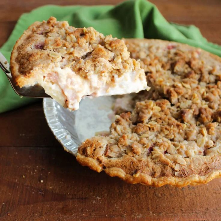 a pie with a slice missing from it on a plate next to a green napkin