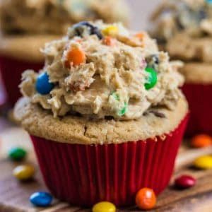 two cupcakes with m & m cookies on top and candy in the middle