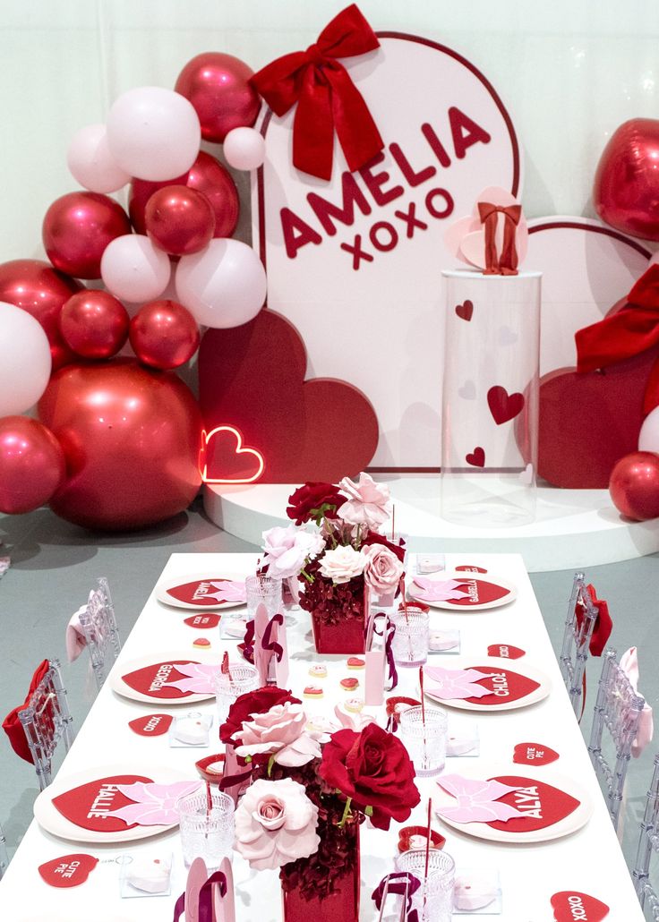 a table set for valentine's day with red and white decorations