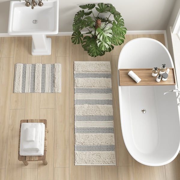 an overhead view of a bathroom with bathtub, sink and rug