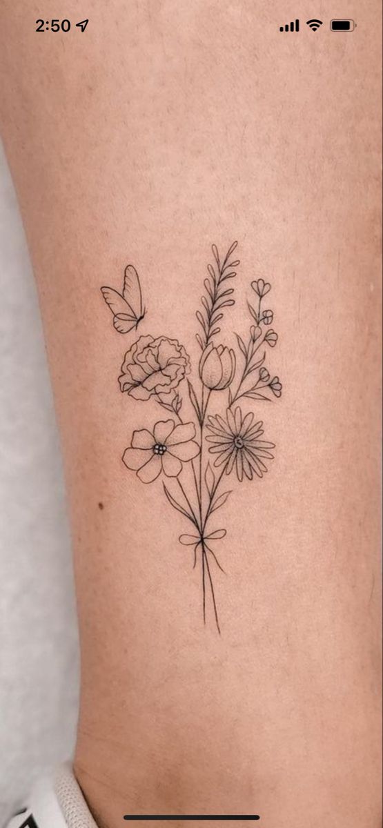 a small flower tattoo on the back of a woman's leg