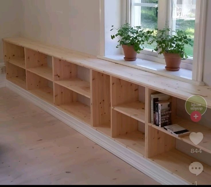 a window sill with bookshelves and potted plants