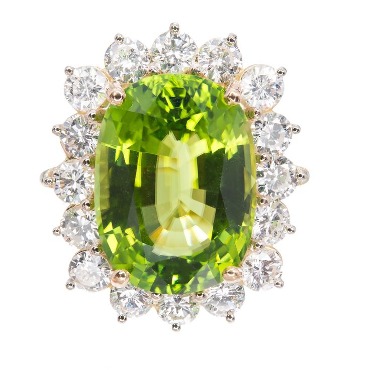 Large cushion Peridot and diamond cocktail ring. GIA certified cushion cut green with hints of yellow, oval center stone with a halo of 16 round diamonds in 18k yellow and white gold setting. The ring was designed and made in the Peter Suchy Workshop. 1 cushion yellowish green Peridot, approx. total weight 14.83cts, VS, GIA certificate #2175646604 16 round diamonds, approx. total weight 2.95cts, G, VS2 Size 6.5 and sizable 18k yellow gold 18k white gold Tested and stamped: 18k 11.4 grams Width a Antique Cushion Cut, Granny Smith Apple, Time Jewelry, Antique Wedding Bands, Diamond Sapphire Engagement Ring, Antique Cushion, Antique Engagement Rings Vintage, Beautiful Gemstones, Yellowish Green