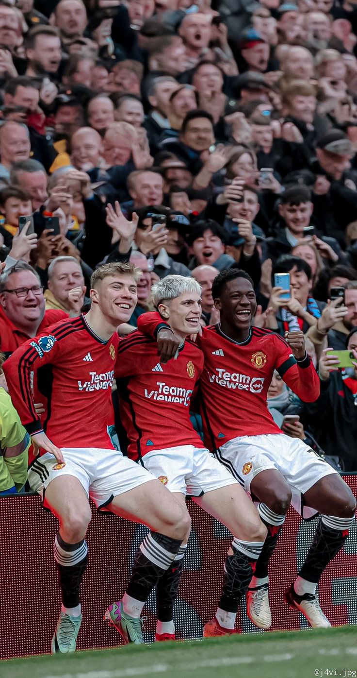 the soccer players are celebrating their team's goal in front of an excited crowd