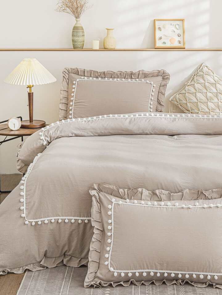 a bed that has some pillows on top of it and a lamp next to it