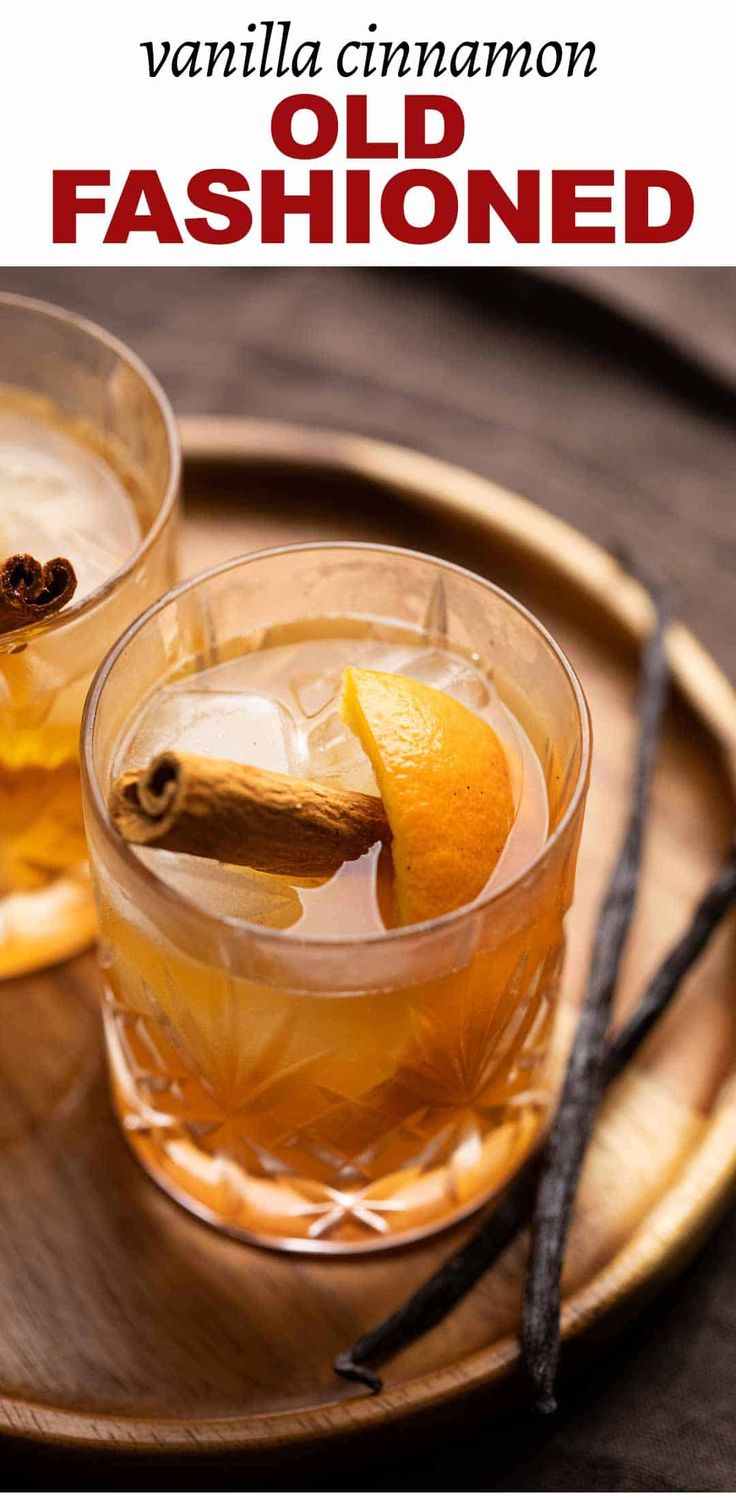 two glasses of old fashioned tea on a wooden tray with cinnamon and an orange peel