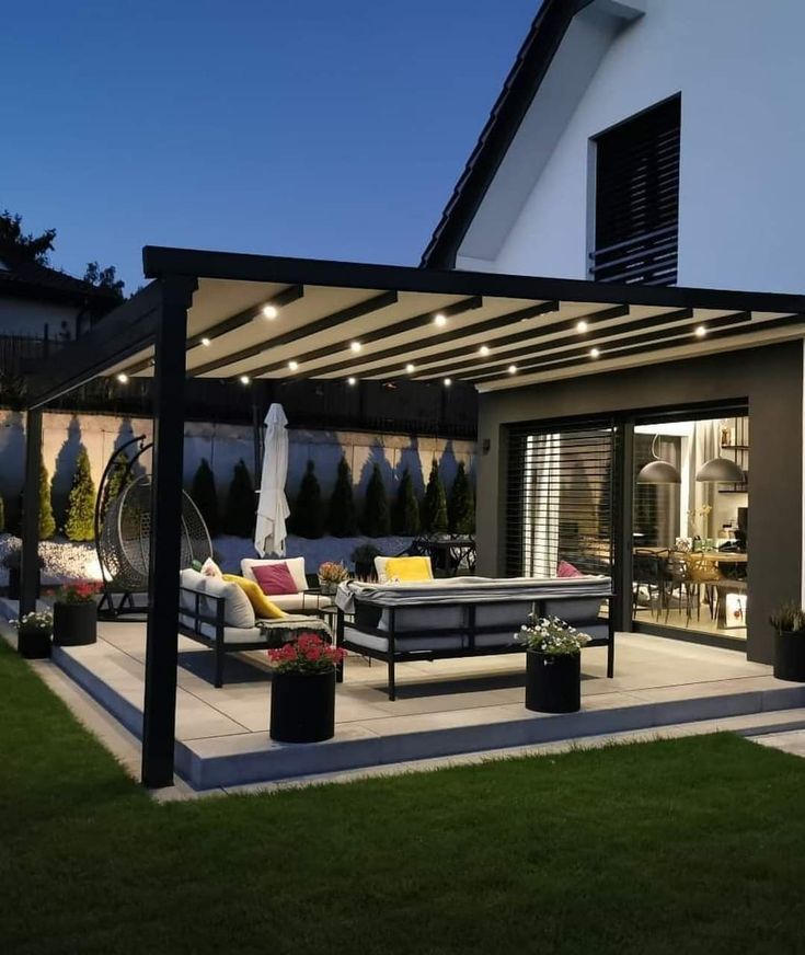 an outdoor living area with patio furniture and lights