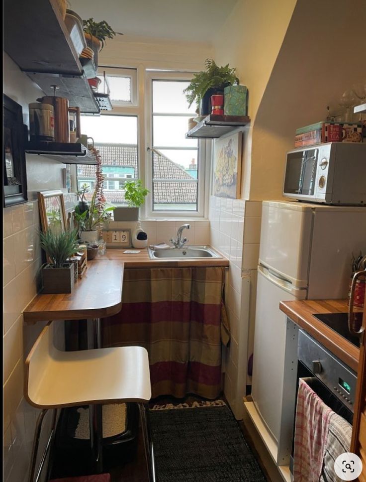 a small kitchen with a sink, stove and microwave in it's corner area