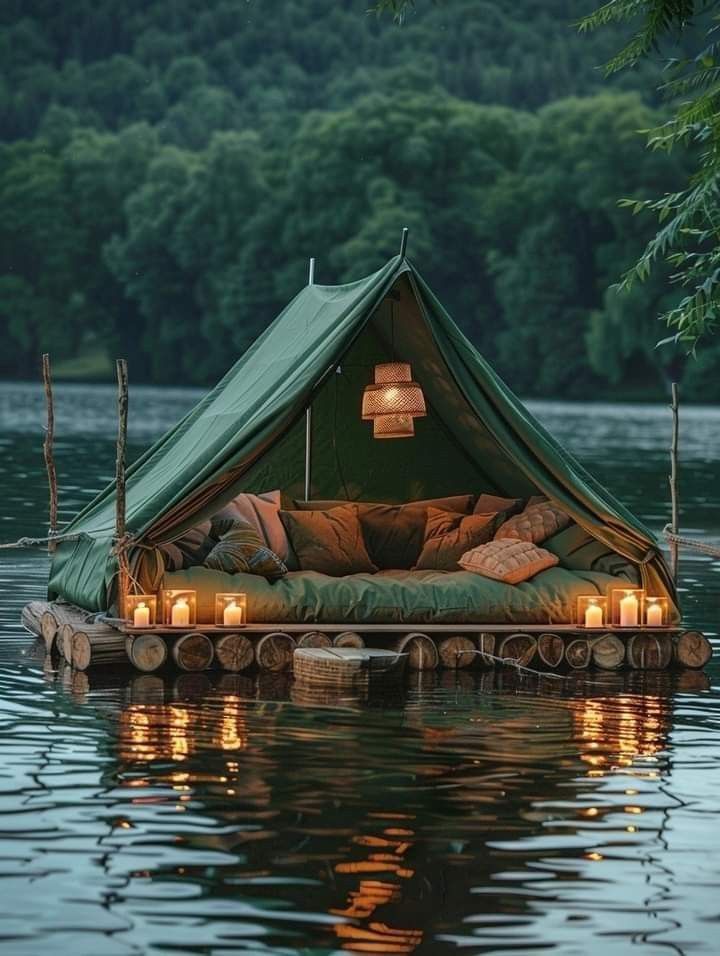 a tent is floating in the water with candles on it