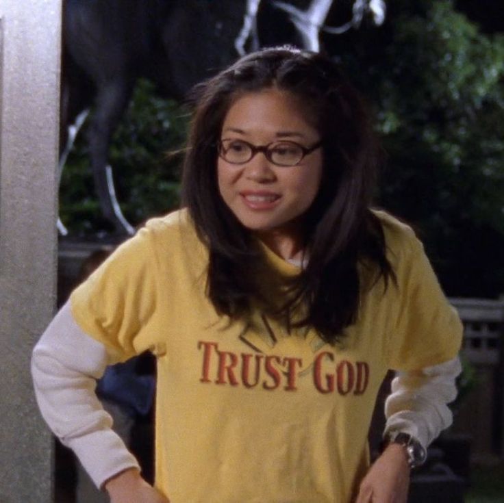 a woman standing in front of a horse statue wearing a trust god t - shirt