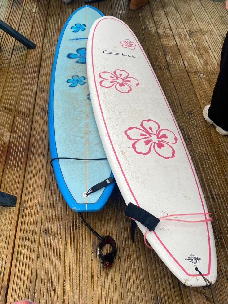 two surfboards sitting on the ground next to each other