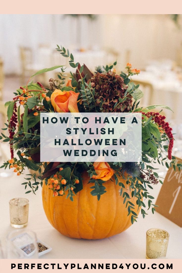 a pumpkin decorated with flowers and greenery is the centerpiece for this halloween wedding