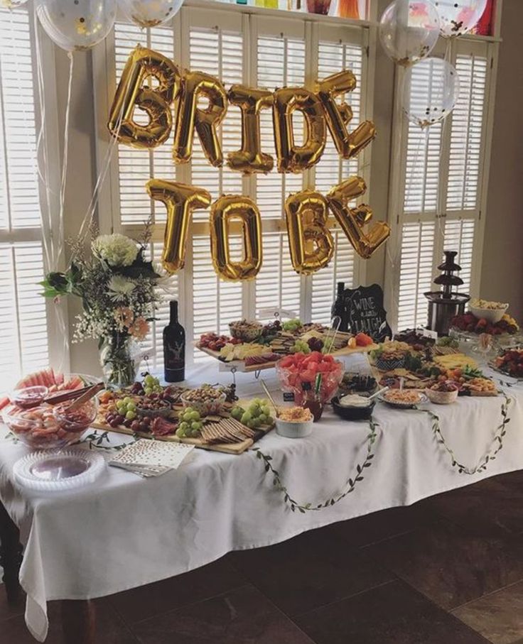 a table topped with lots of food and balloons