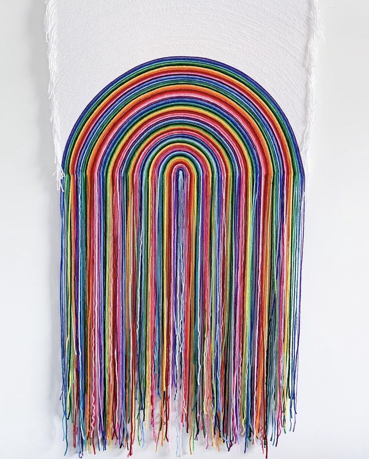 a multicolored wall hanging with fringes on it