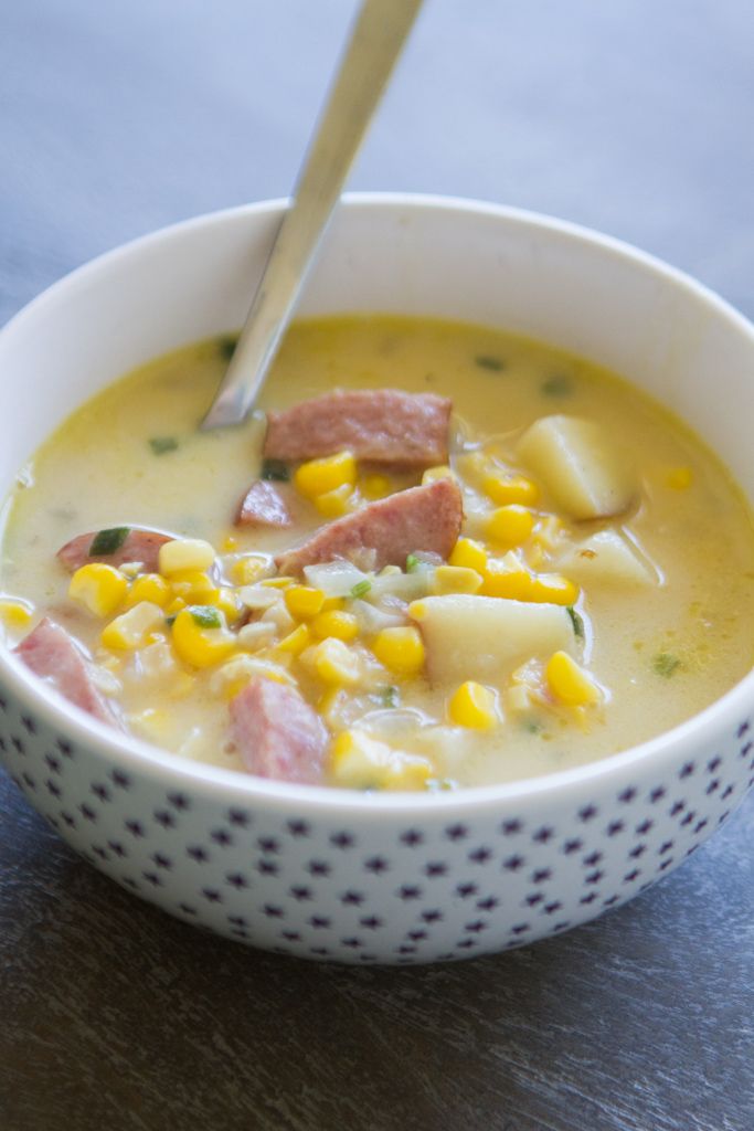 a white bowl filled with corn and ham soup