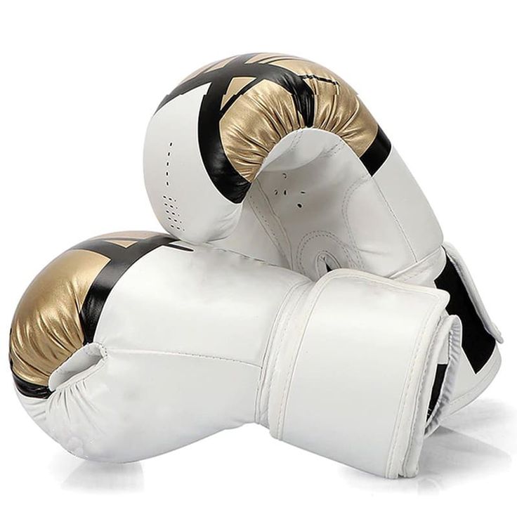 two white and gold boxing gloves laying on top of each other