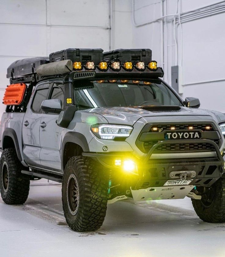 a toyota truck with its lights on in the snow