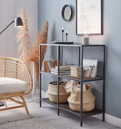 a shelf with baskets on it next to a chair