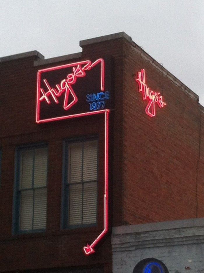 two neon signs on the side of a building