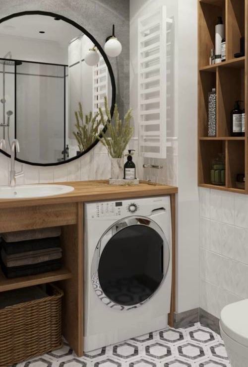 a washer and dryer in a bathroom next to a sink with a mirror above it