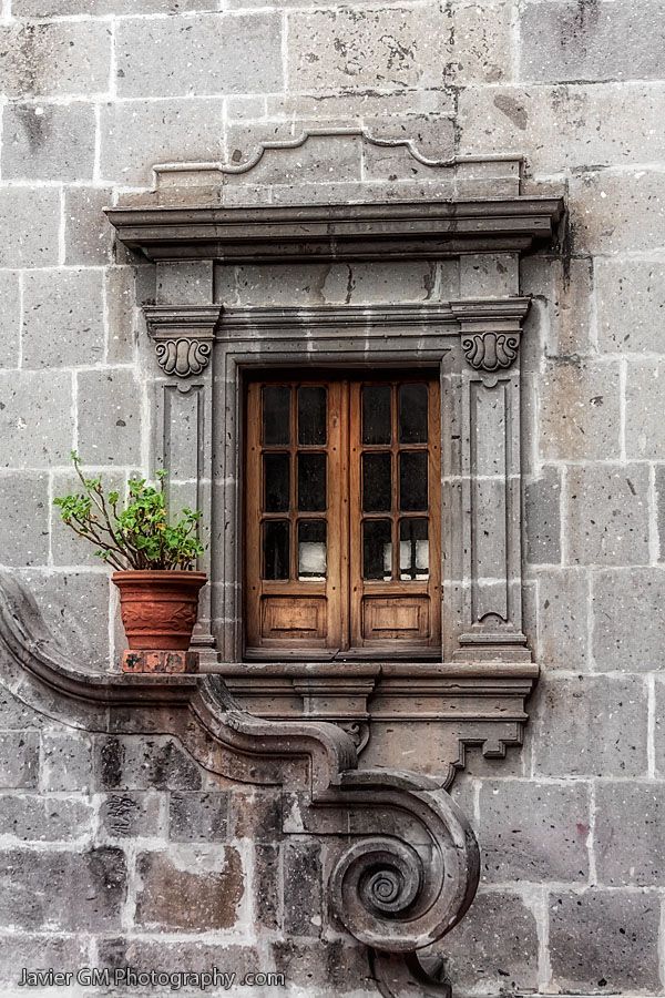 an old building with a window and planter on the ledge