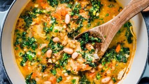 a white bowl filled with soup and a wooden spoon